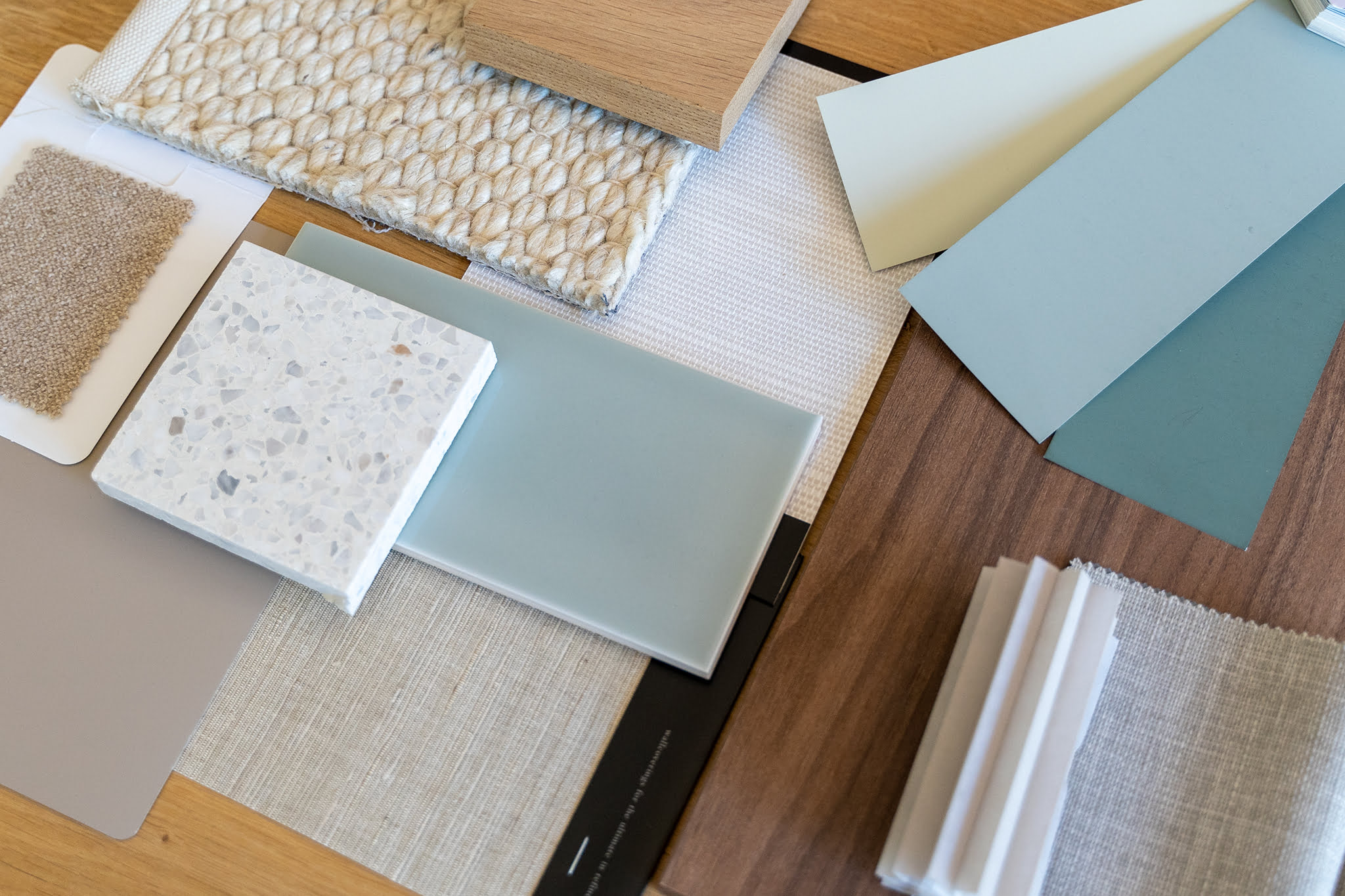 Stalenoverzicht voor bij een interieuradvies. Verschillende materialen, zoals tegels, behang, raamdecoratie, wollen vloerkleed en eikenhout.